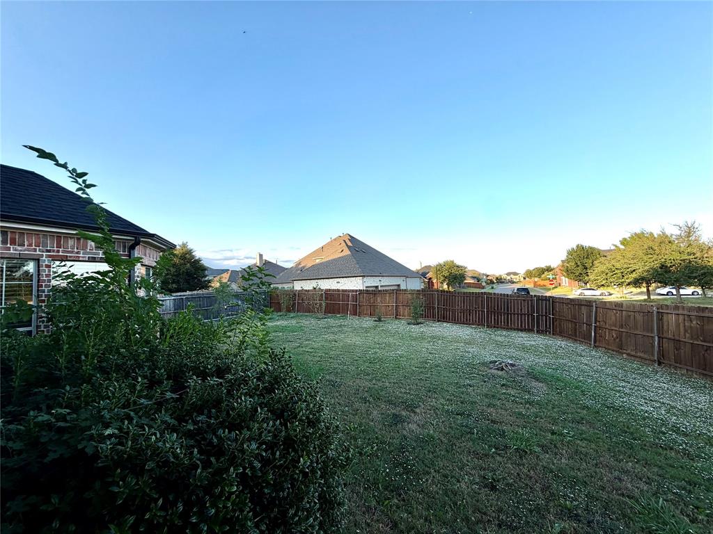 Backyard featuring a grass lawn and a wood privacy fence