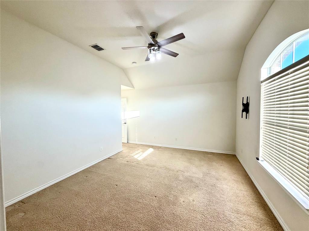 Vaulted ceiling featuring a central light-integrated ceiling fan and an arched window with horizontal blinds