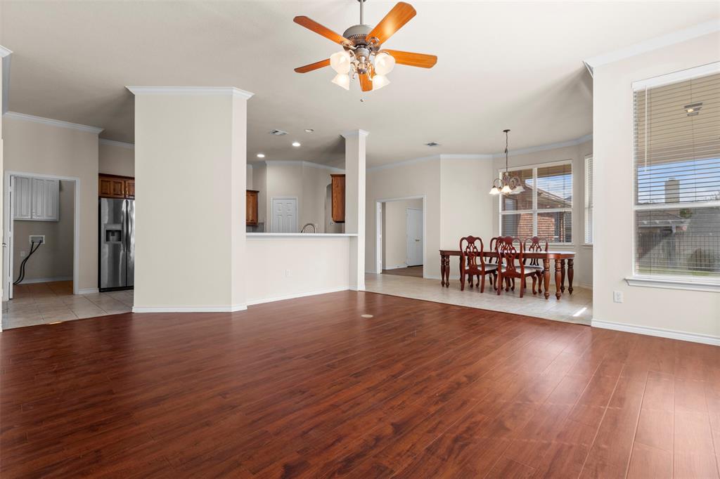 Open-concept floor plan featuring wood-finish flooring, recessed lighting, a ceiling fan, and multi-pane windows with horizontal blinds