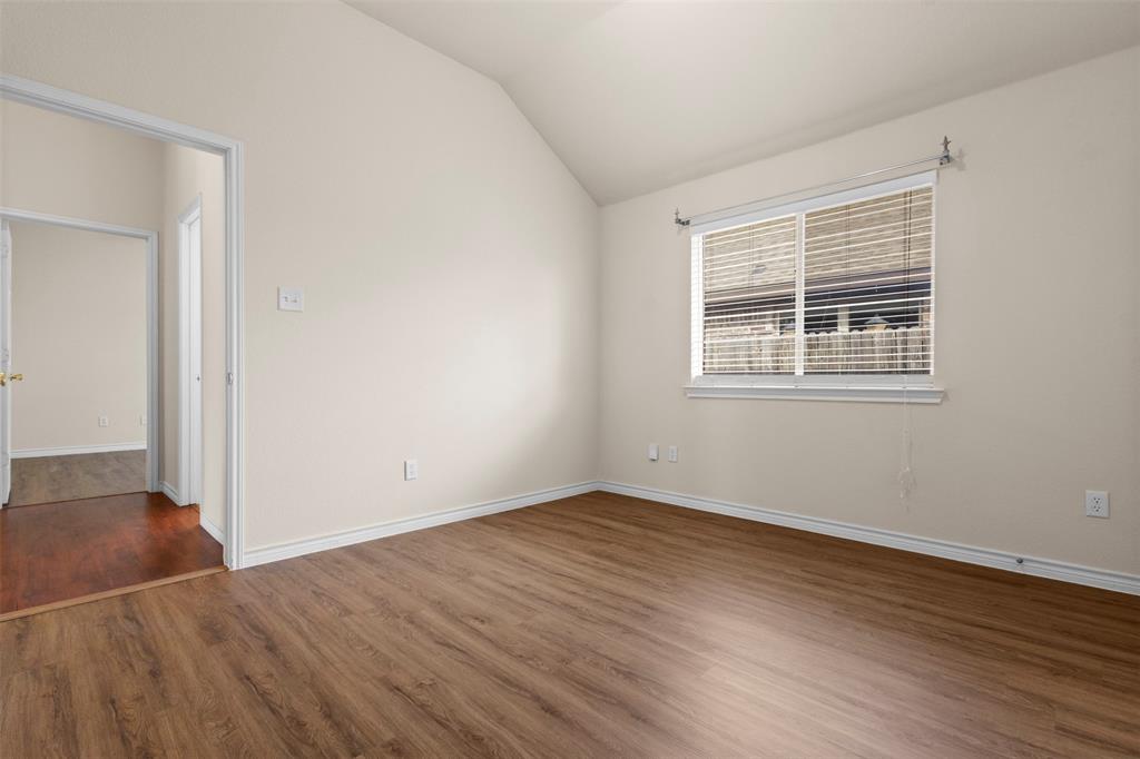 Vaulted ceiling, wood-finish flooring, and natural light provided by a single-pane window