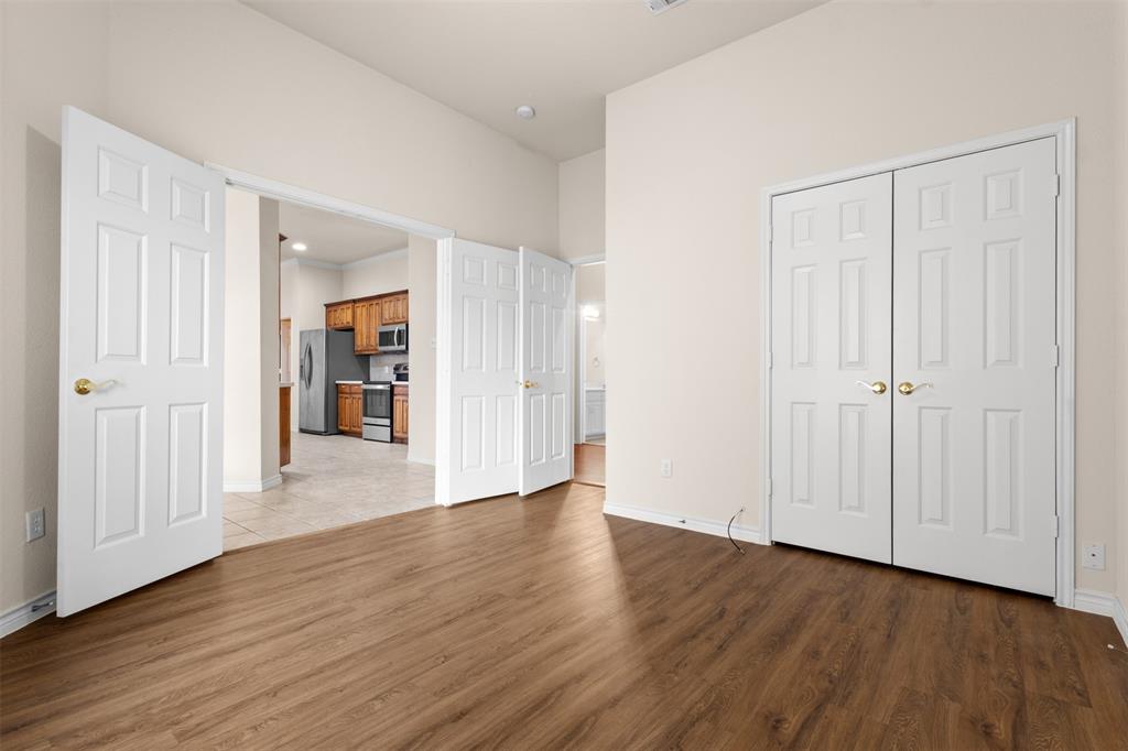 Interior room featuring wood-finish flooring, double-panel interior doors, and high ceilings