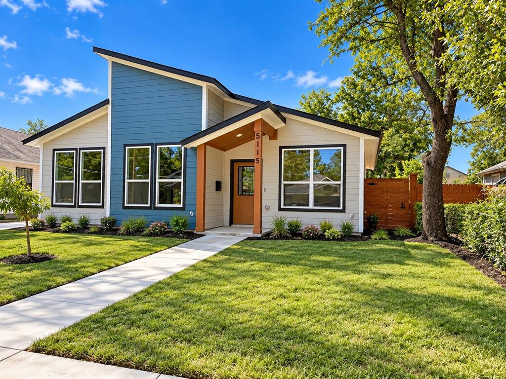 Modern exterior featuring horizontal lap siding, an asymmetrical roofline, a covered porch with timber support beams, and decorative horizontal wood fencing
