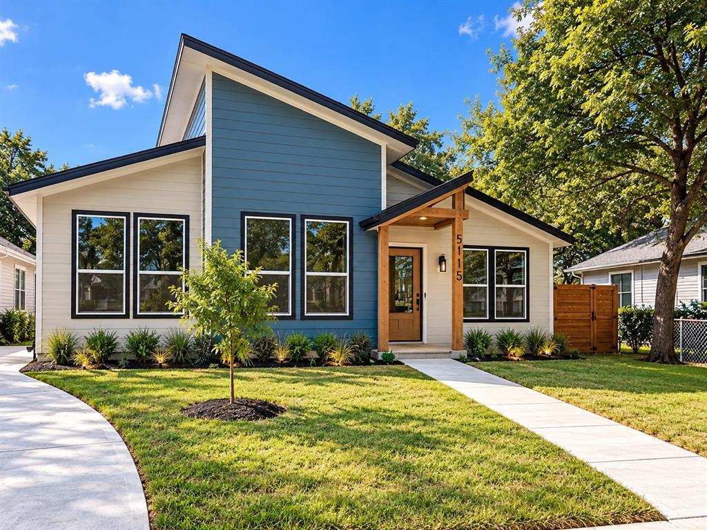 Modern residence featuring a single-slope roofline, two-tone siding, a timber-framed entryway, and a paved walkway