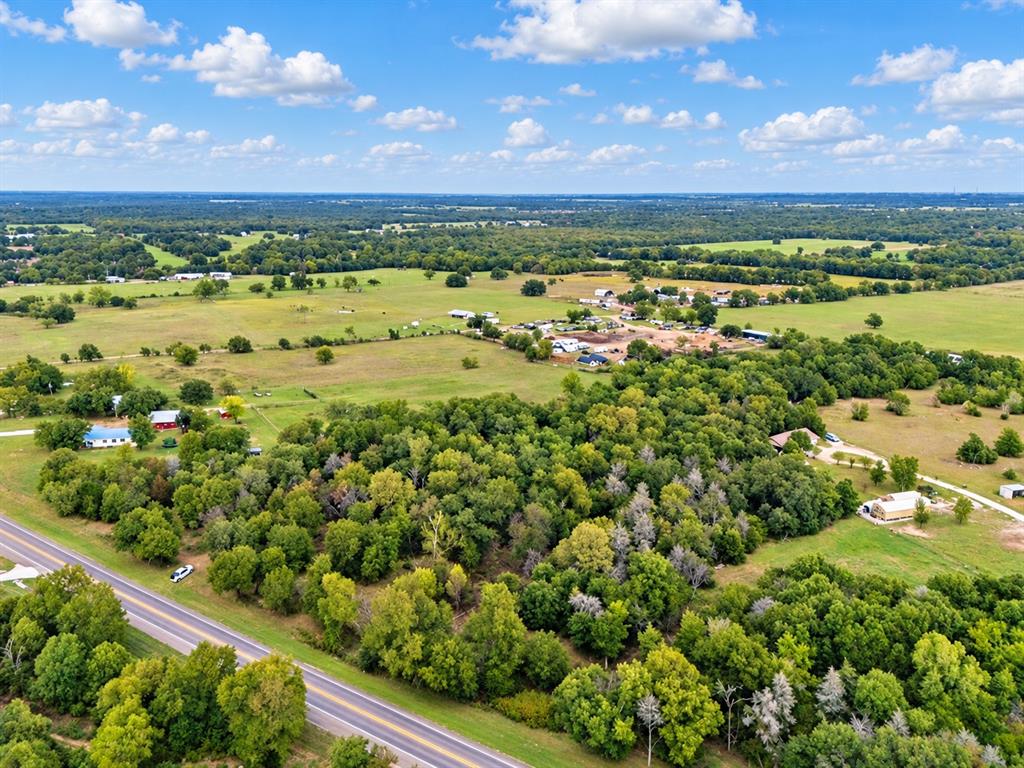 Expansive acreage featuring mature tree stands, open pasture land, and direct frontage to a paved roadway