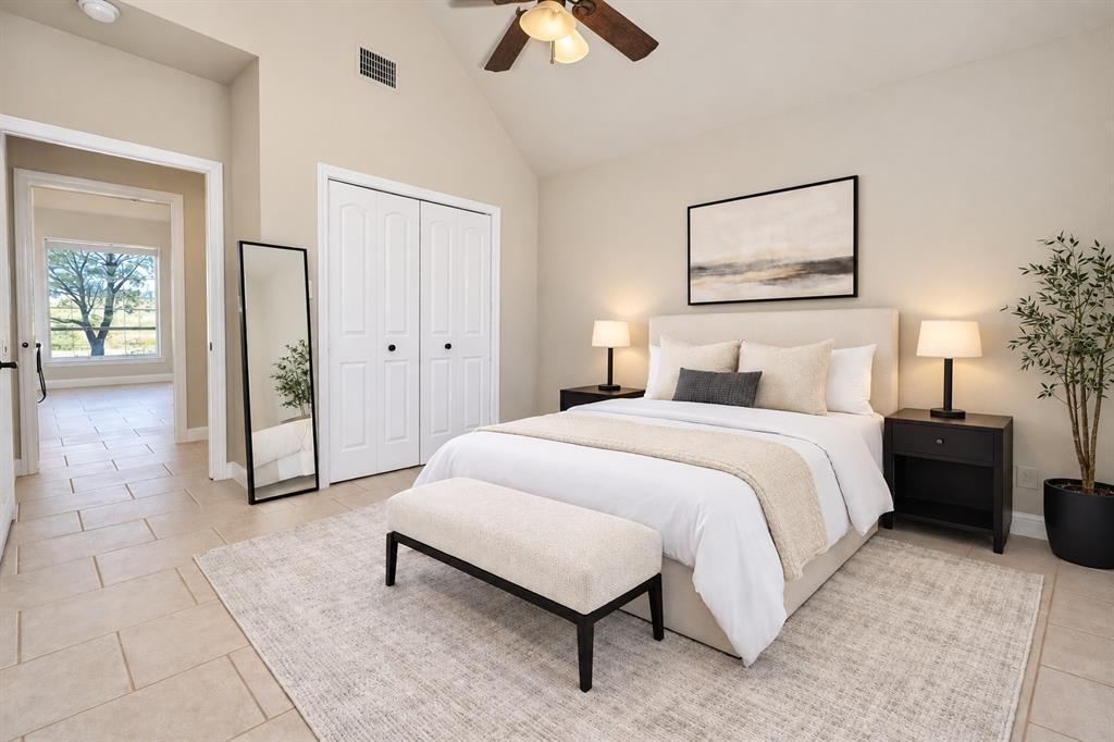 Vaulted ceilings featuring a central ceiling fan and neutral tile flooring