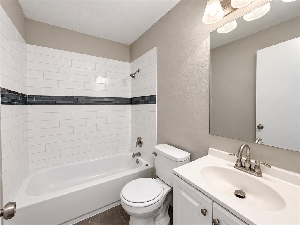 Full bathroom featuring a tiled tub and shower combination with modern finishes.