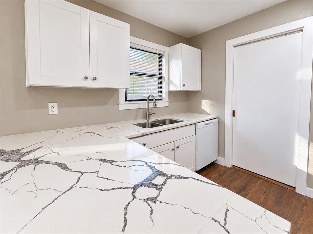 Updated kitchen featuring white cabinetry, quartz countertops, and a double-basin sink. Updated kitchen featuring white cabinetry, quartz countertops, and a double-basin sink.
