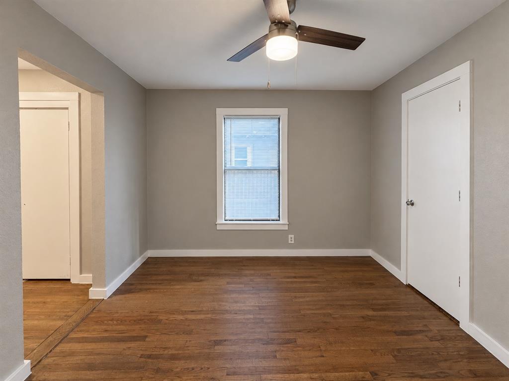 Bedroom featuring wood flooring, neutral wall colors, and a ceiling fan.