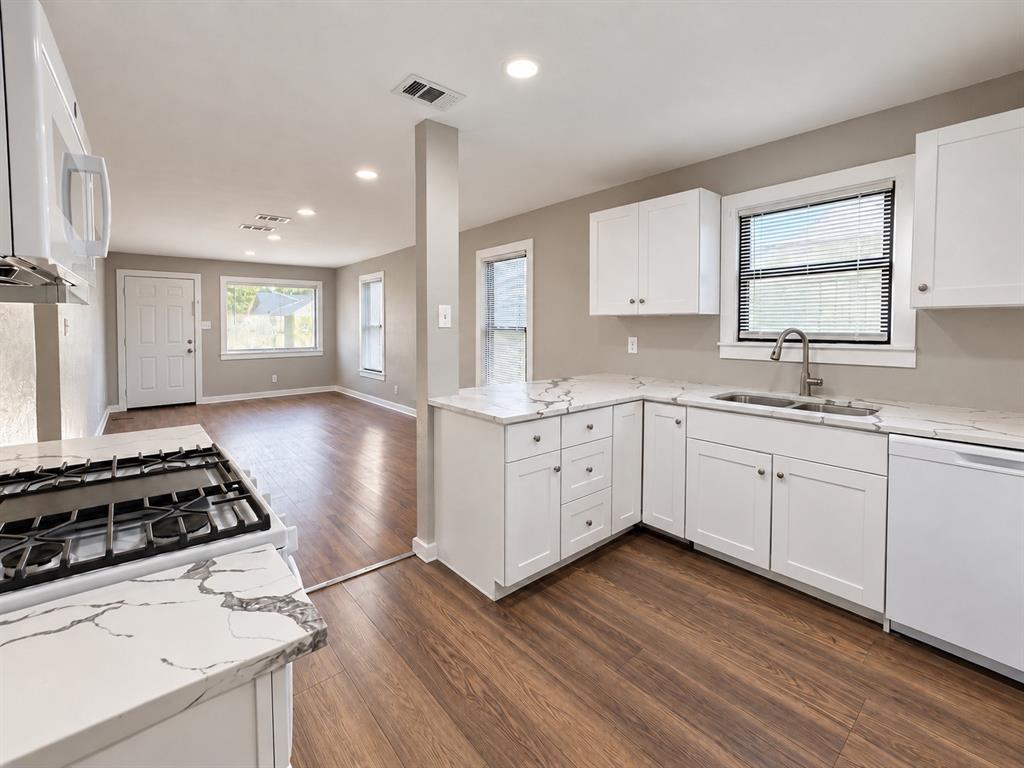 Functional kitchen layout featuring white cabinetry, modern finishes, and ample counter space. Functional kitchen layout featuring white cabinetry, modern finishes, and ample counter space.