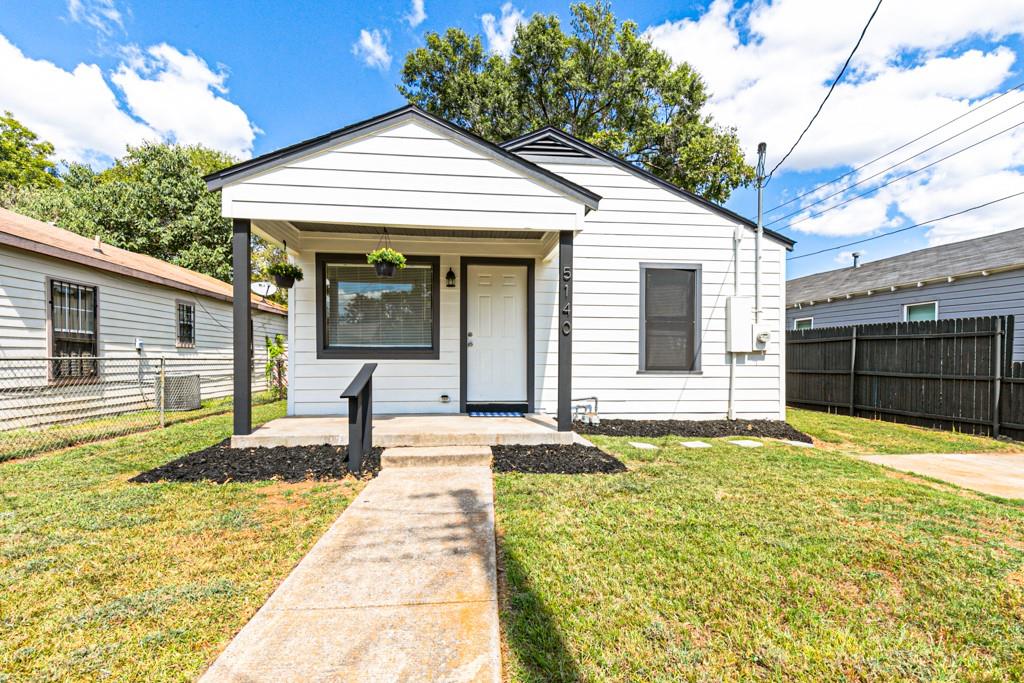 Charming exterior featuring a covered front porch, welcoming entry, and spacious front yard.