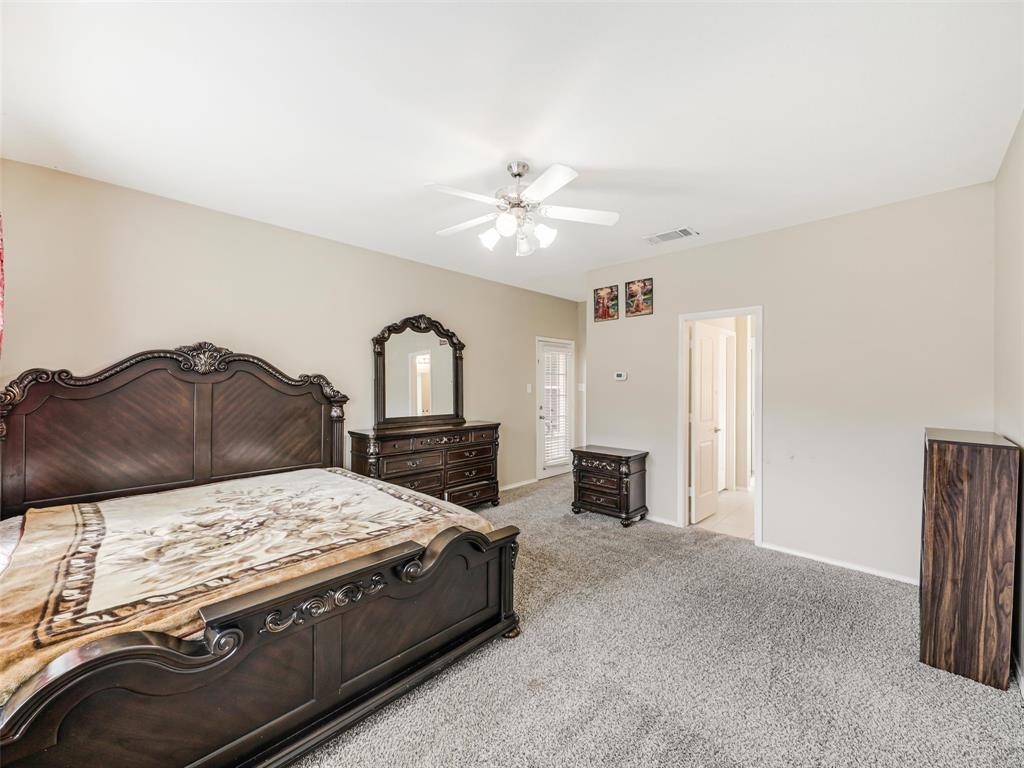 Neutral wall tones, carpeting, ceiling fan with integrated lighting, and glass-paneled exterior door