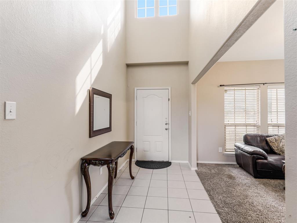 Entryway featuring high ceilings, transom windows, and light-toned tile flooring