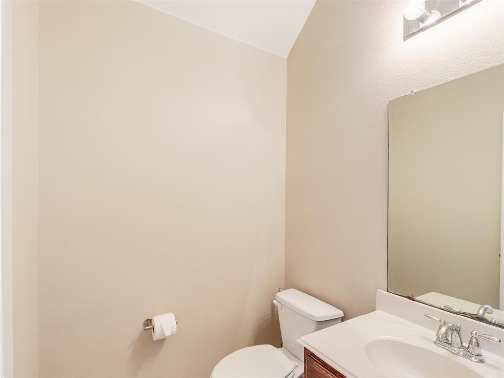 Wall-mounted vanity featuring a solid surface countertop, integrated oval basin, metallic faucet, large rectangular mirror, and overhead light fixture