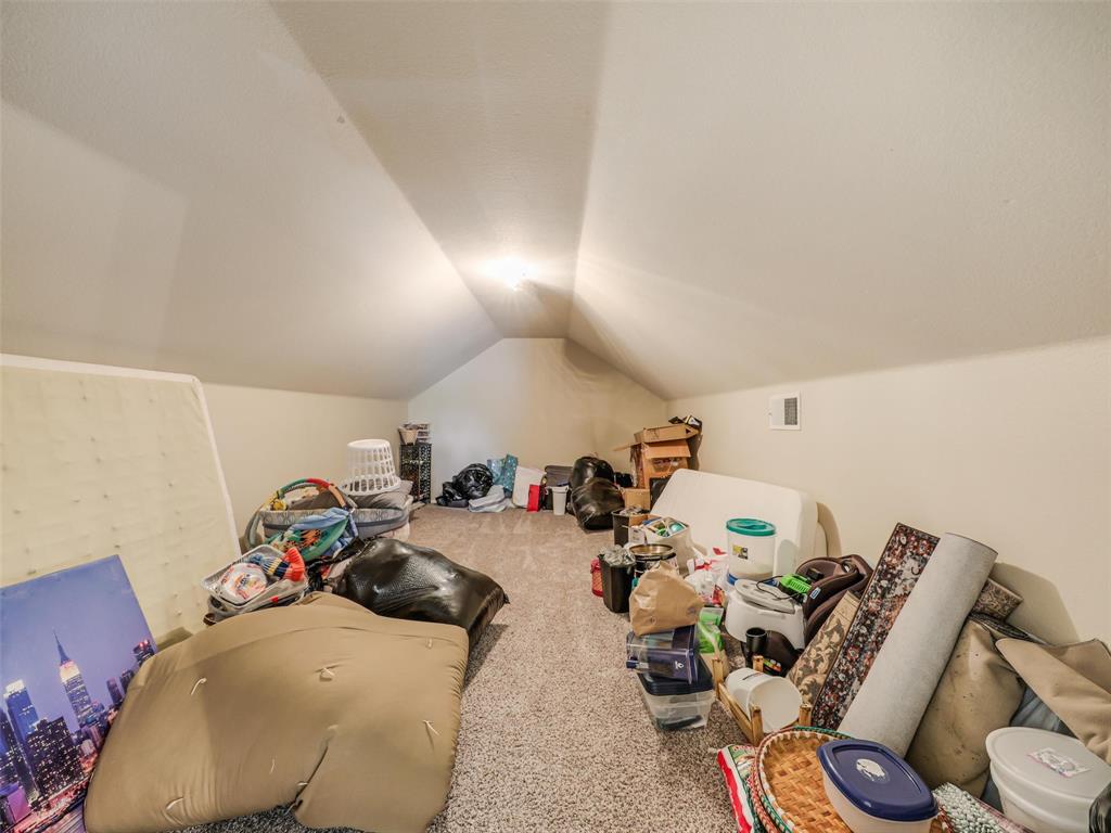 Finished attic space featuring vaulted ceilings and carpeting