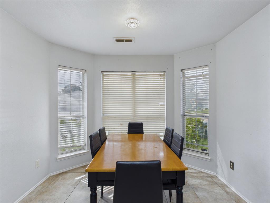 Bay window featuring neutral tile flooring, multi-pane windows with horizontal blinds, and a central flush-mount ceiling light fixture