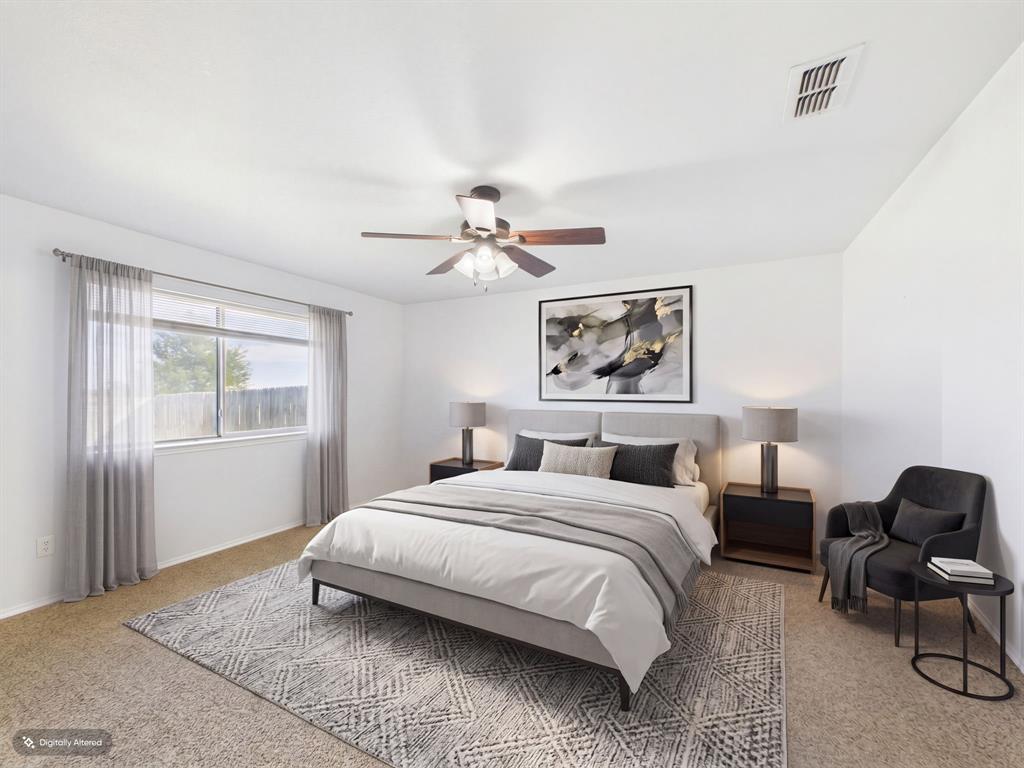 Neutral-toned interior room featuring wall-to-wall carpeting, a multi-blade ceiling fan with integrated lighting, and a single-pane window
