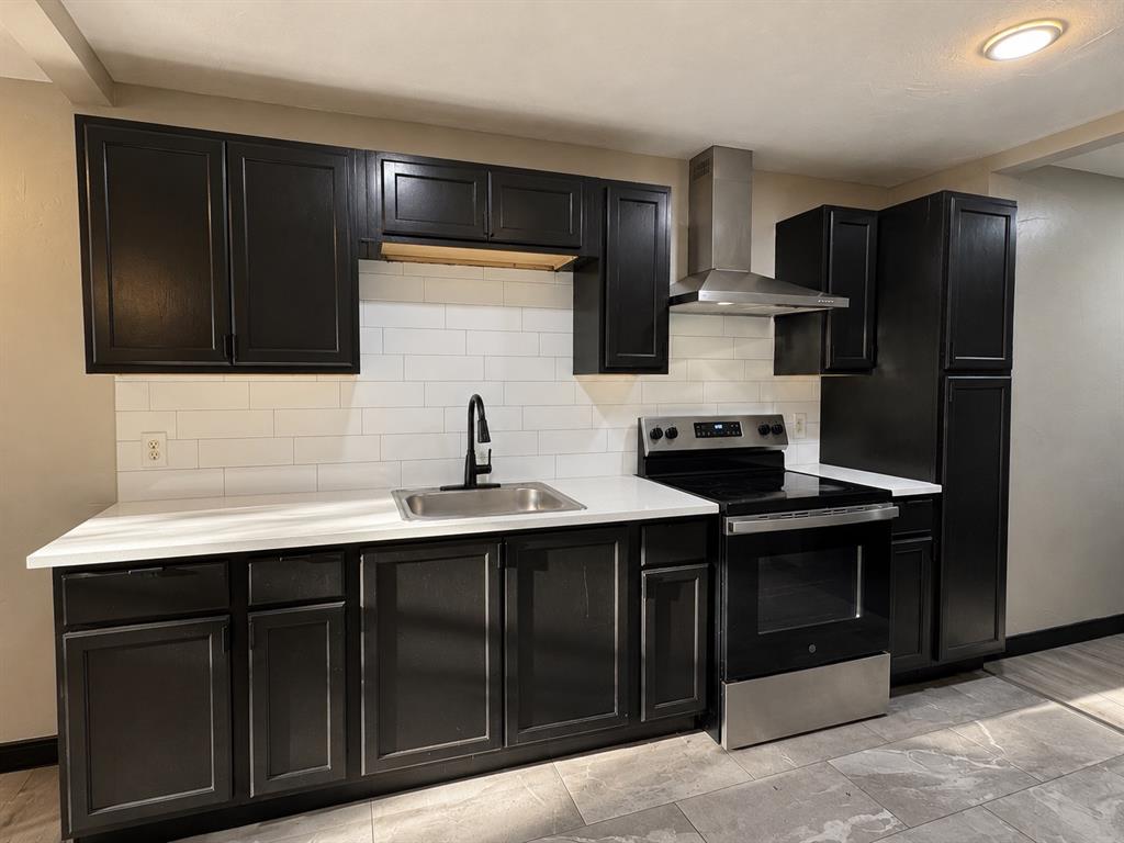 kitchen featuring dark cabinetry, light countertops, and a classic subway tile backsplash.