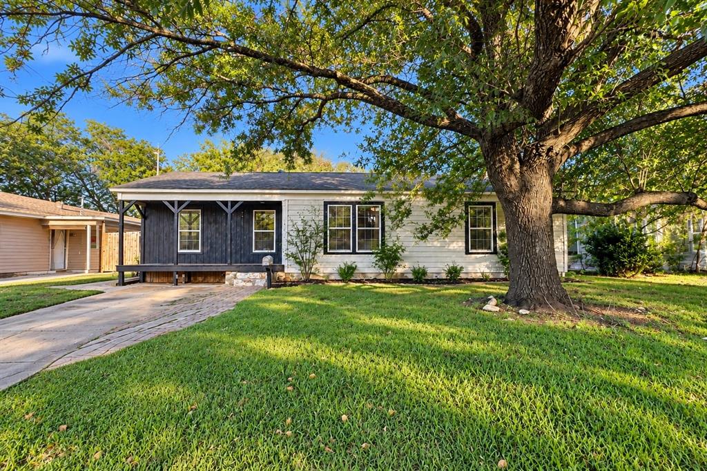 Charming cottage-style home with a welcoming covered front porch and mature trees.