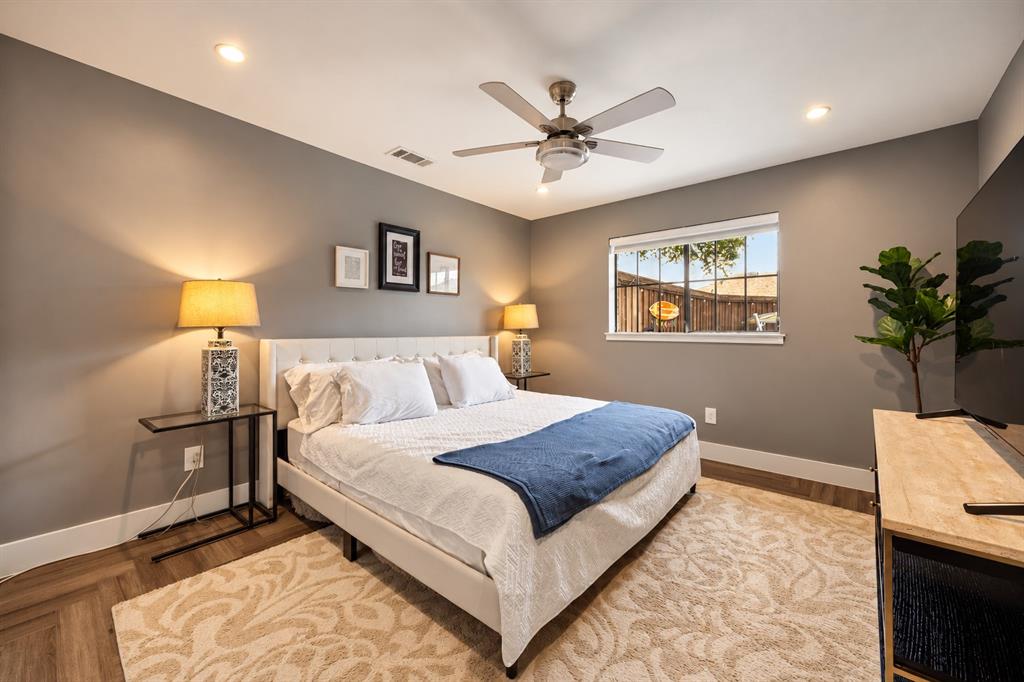 Neutral-toned room featuring wood-finish flooring in a herringbone pattern, recessed lighting, and a multi-blade ceiling fan with integrated lighting