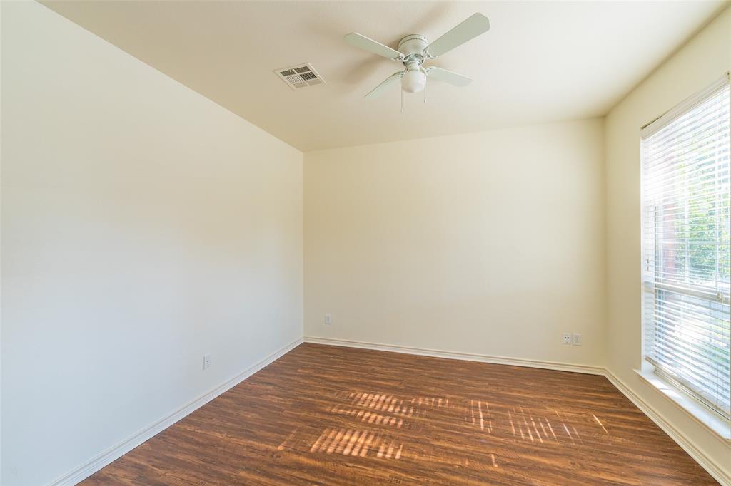 Room featuring wood-finish flooring, neutral wall paint, a ceiling fan with integrated lighting, and a large window with horizontal blinds