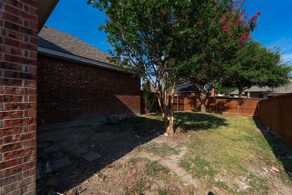 Exterior brick siding, mature trees, and wooden privacy fencing