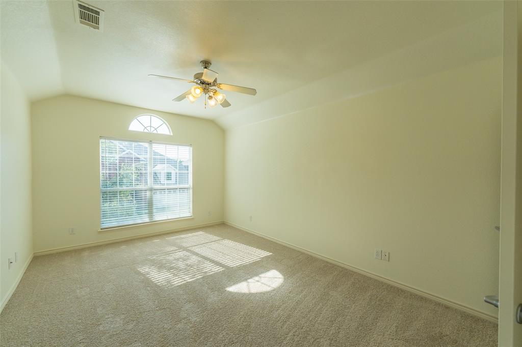 Vaulted ceilings, carpeted flooring, multi-pane window with arched transom, and integrated ceiling fan with multi-light fixture