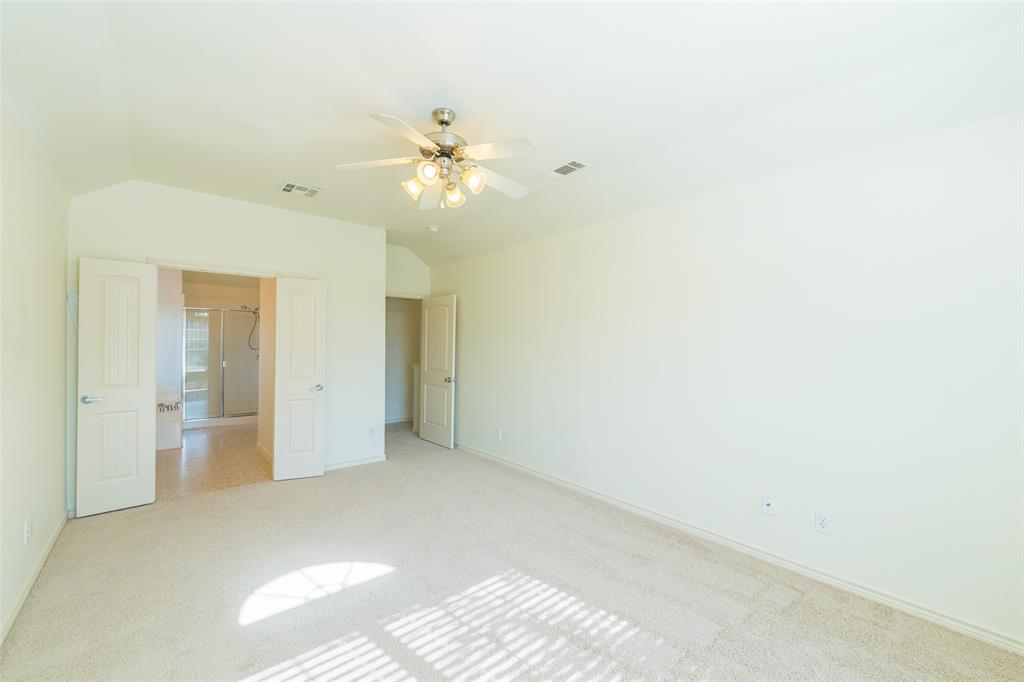 Vaulted ceilings, neutral carpeting, and a multi-blade ceiling fan with integrated lighting