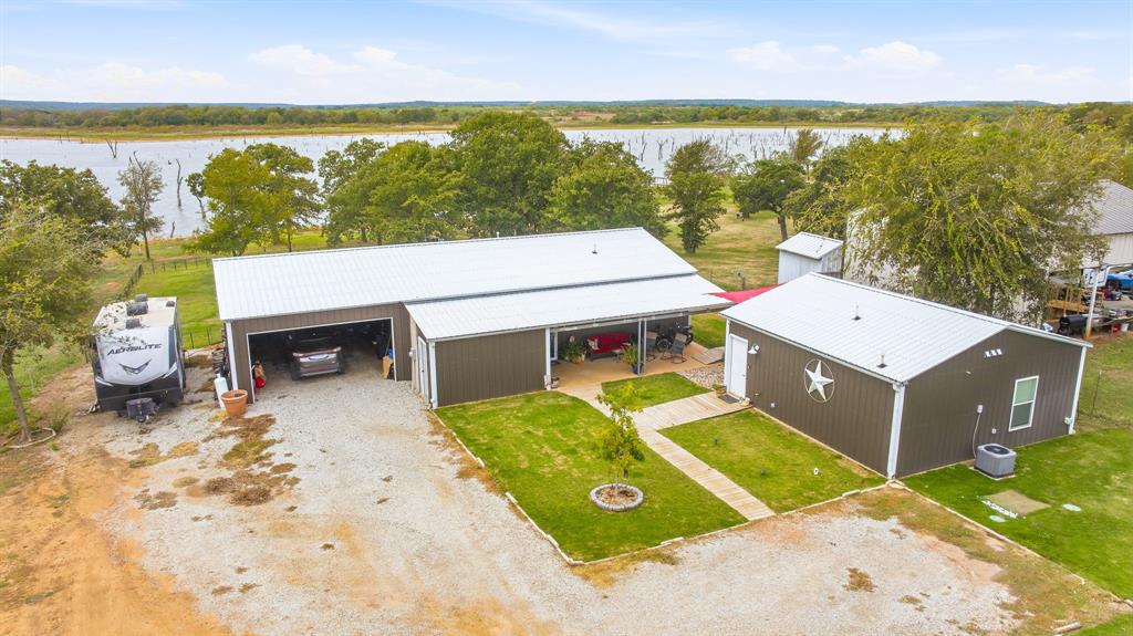 Aerial View of improvements: The 1200 square foot main house with 600 square foot garage.  The house with the Texas Star is a one bedroom handicap accessible efficiency apartment with kitchen, dining, bathroom, and laundry