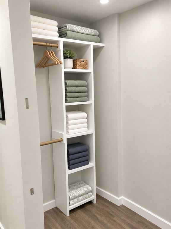 Closet featuring white built-in shelving, wood-finish hanging rods