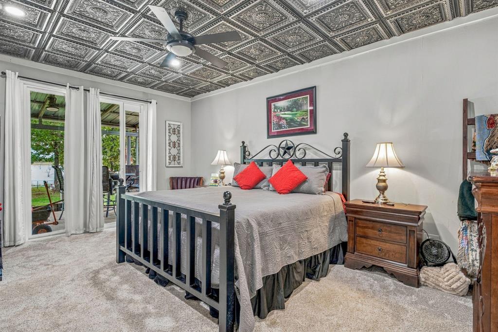 Ornate coffered ceiling with detailed pressed-tin panels, recessed lighting, and a central ceiling fan.  Sliding glass door open to covered back porch.