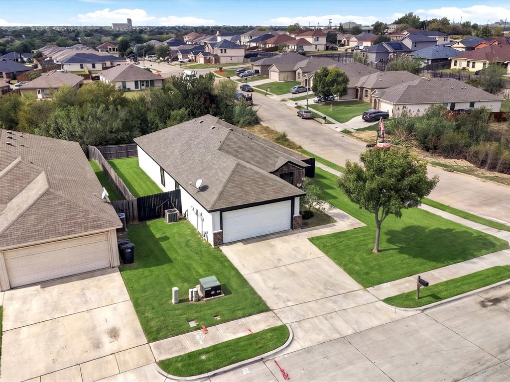 Single-story residence featuring a shingled roof, attached two-car garage, concrete driveway, and a fenced backyard