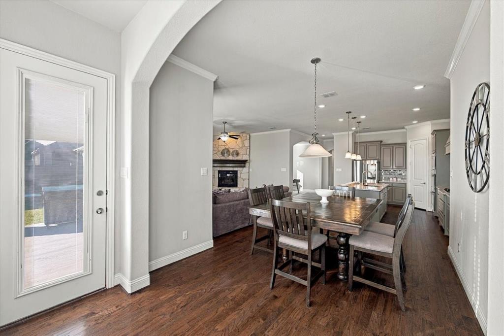 Dining Area features a full-lite door to the covered patio and an archway opening to the living room, with an open layout connecting to the kitchen. Wood flooring extends throughout.