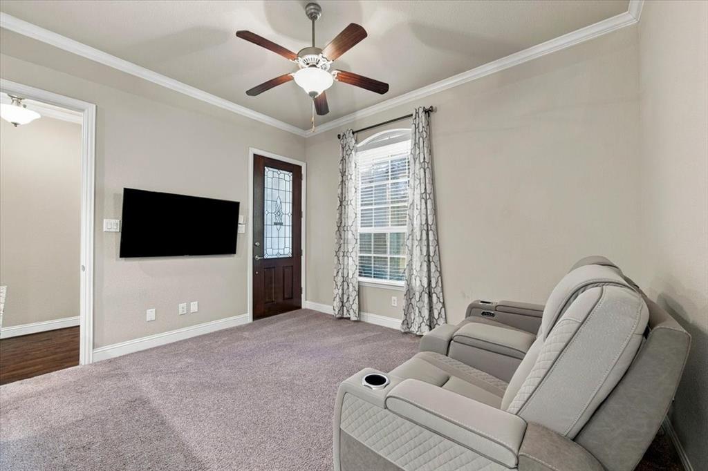 Suite Sitting Room features an arched-top window, a private exterior entry door with decorative glass, and a doorway connecting to the main foyer. Carpet flooring extends throughout, transitioning to wood in the foyer.