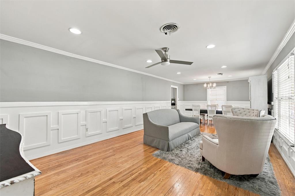 Living space featuring wood-finish flooring, white picture frame wainscoting, recessed lighting, and a brushed nickel ceiling fan