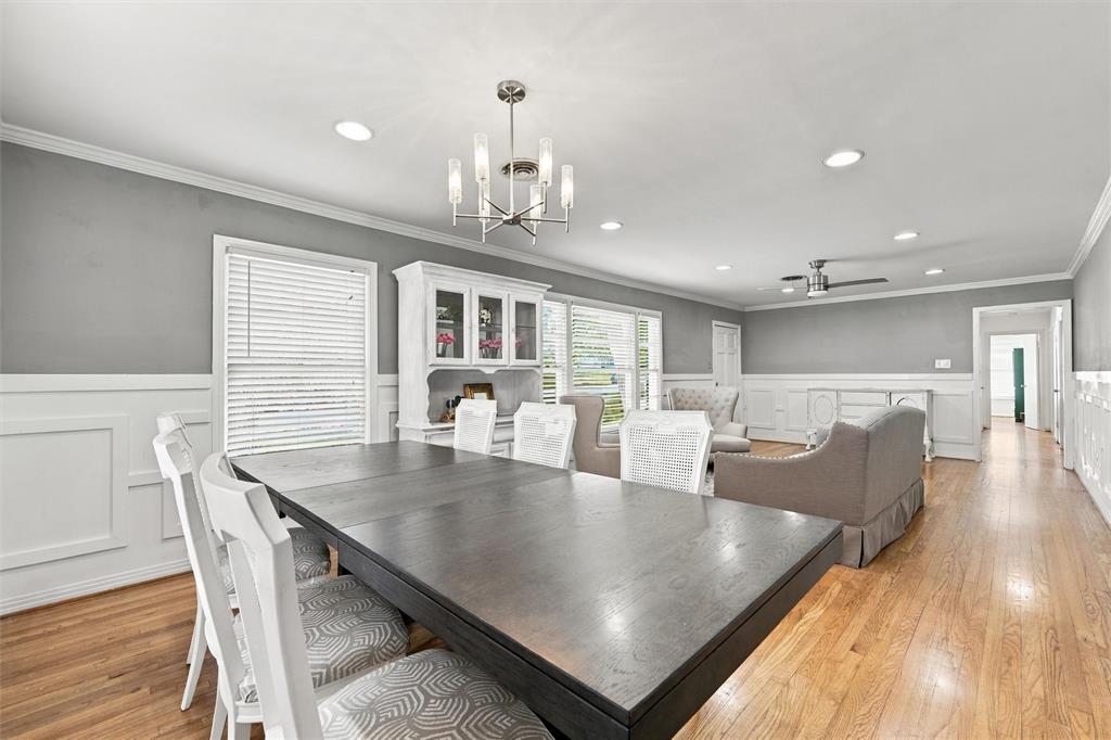 Open-concept interior featuring wood-finish flooring, wainscoting, recessed lighting, and a multi-arm chandelier