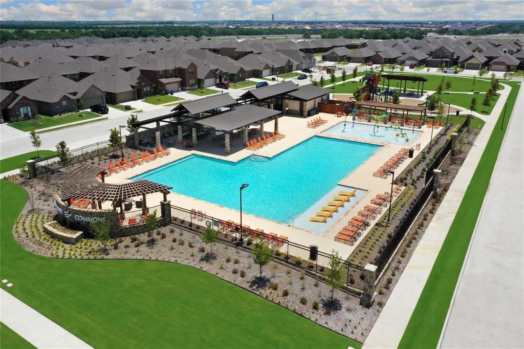 Community recreation area featuring a large swimming pool, splash pad, covered pavilion with timber-frame structures, and landscaped grounds