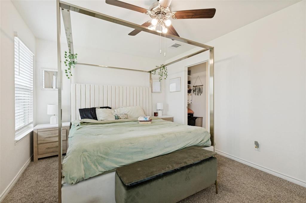 Neutral-toned room featuring a ceiling fan with integrated lighting, wall-to-wall carpeting, and a window with horizontal blinds