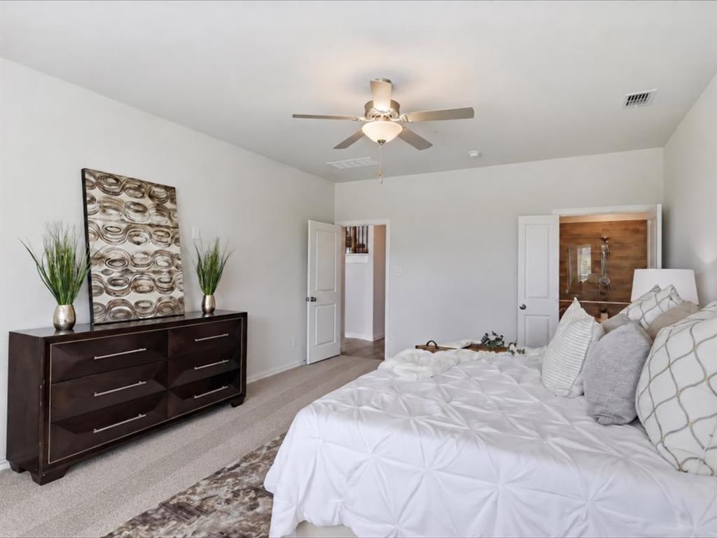 Room featuring neutral wall tones, wall-to-wall carpeting, a multi-blade ceiling fan with integrated lighting, and white interior doors