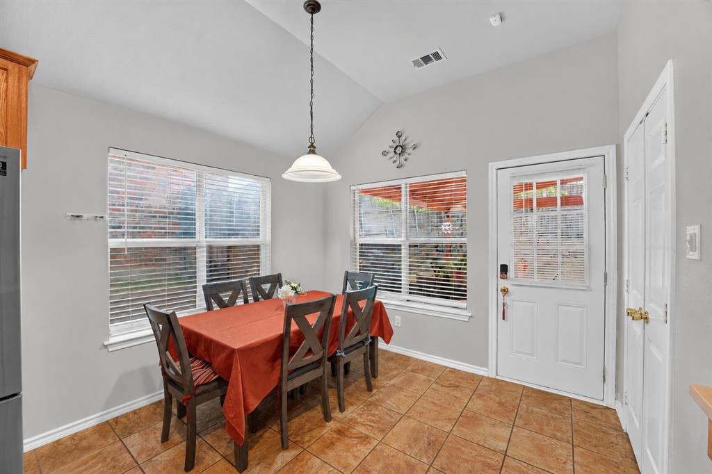 Vaulted ceilings, neutral wall tones, ceramic tile flooring, single-pendant overhead lighting, and multi-pane glass entry door