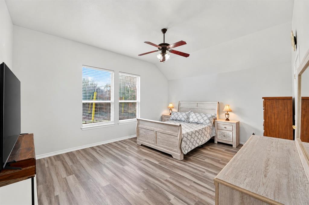 Vaulted ceiling, wood-finish flooring, and double windows with horizontal blinds