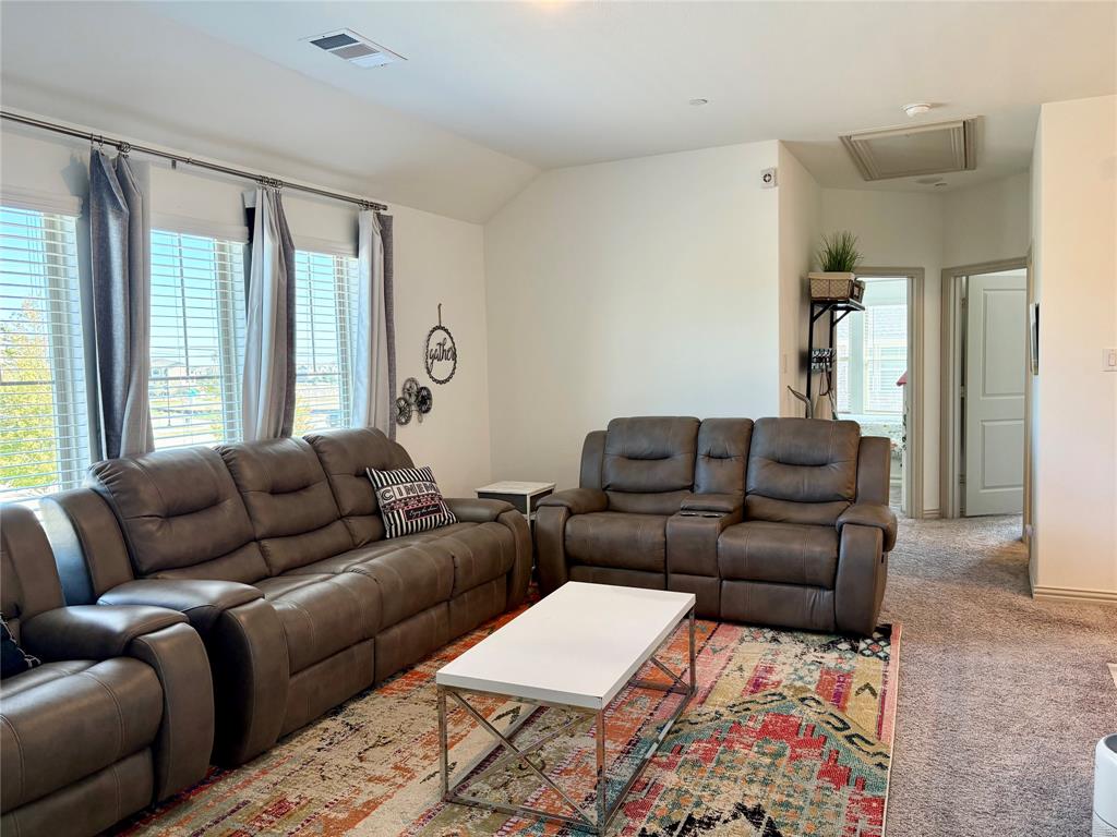 Vaulted ceilings, expansive windows with horizontal blinds, and neutral wall color