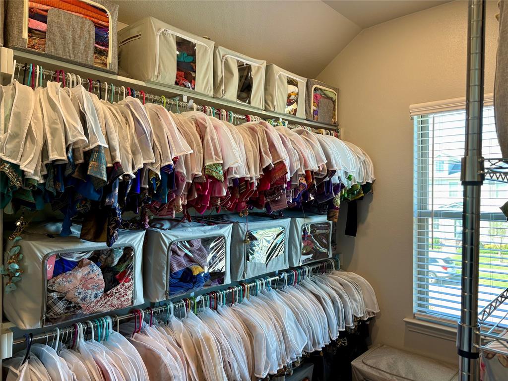Multi-tier metal closet shelving system featuring horizontal hanging rods and adjustable window blinds