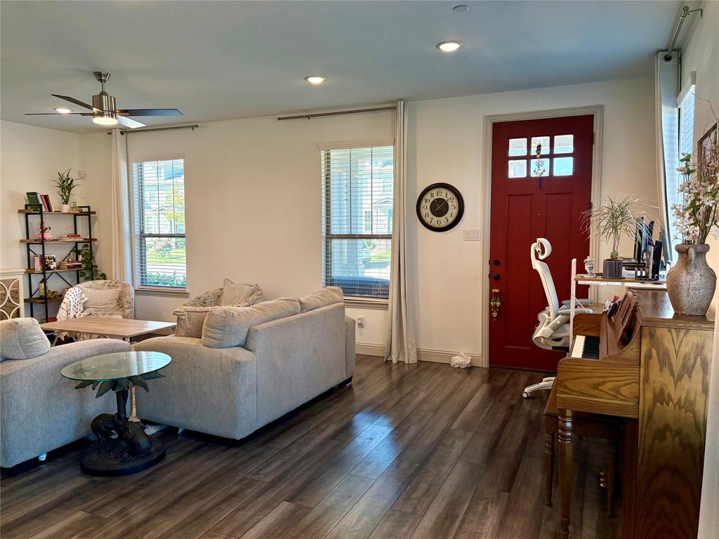 Wood-finish flooring, recessed lighting, ceiling fan with light kit, double-hung windows, and a multi-pane solid wood entry door