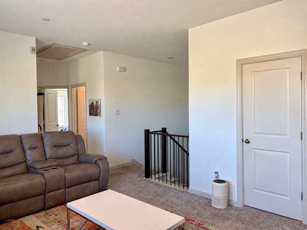 Neutral-toned carpeting, recessed ceiling lighting, and a staircase featuring a metal balustrade