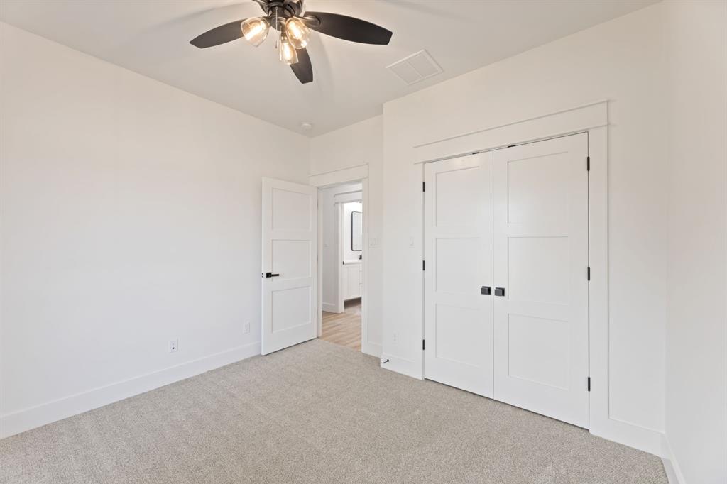 Unfurnished bedroom featuring light colored carpet, baseboards, ceiling fan, visible vents, and a closet