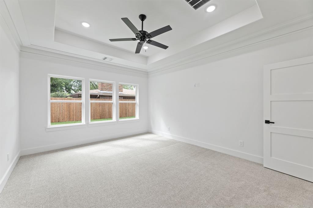 Carpeted spare room with visible vents, a tray ceiling, baseboards, and recessed lighting