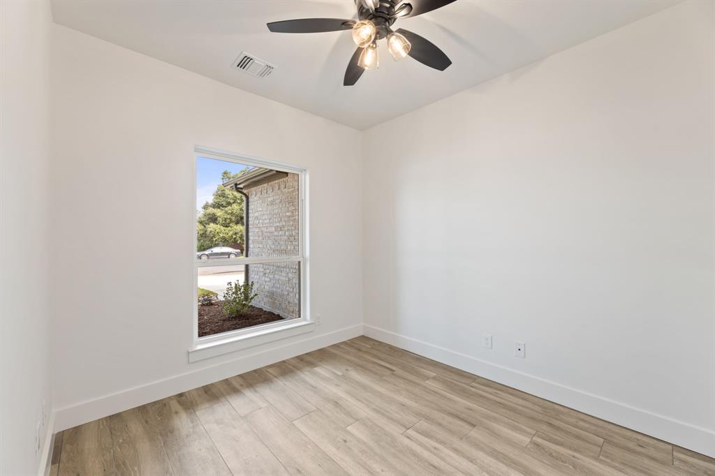 Empty room with a ceiling fan, light wood-style flooring, baseboards, and visible vents