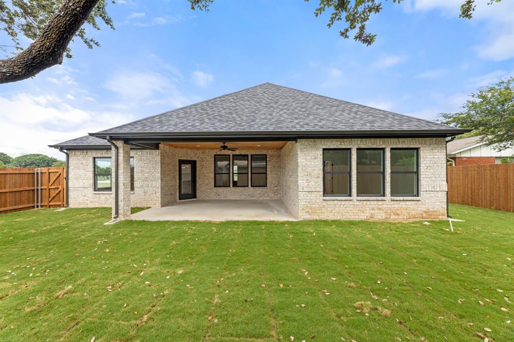 Rear view of property with a patio, ceiling fan, a fenced backyard, and a yard