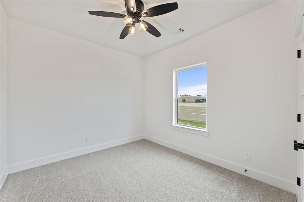 Unfurnished room with a ceiling fan, baseboards, light colored carpet, and visible vents