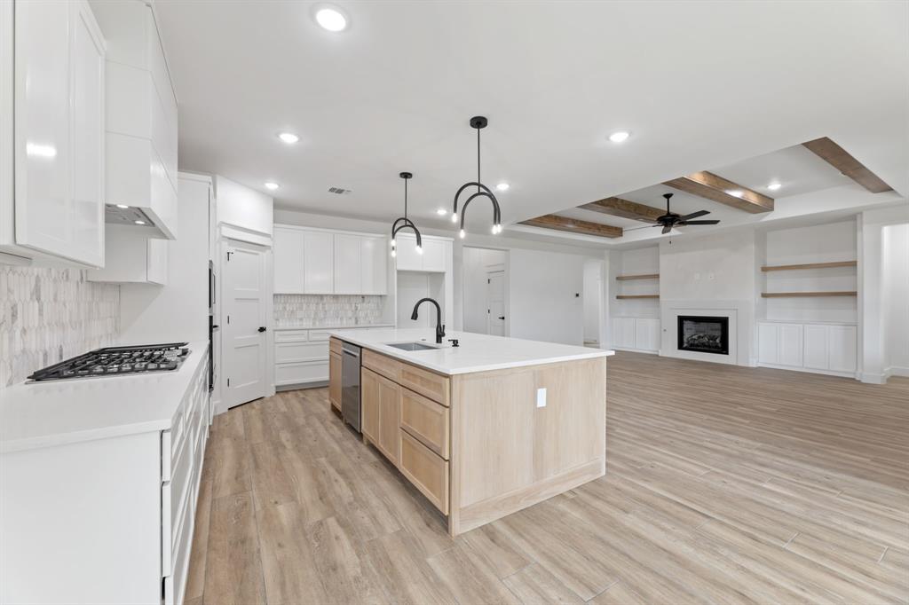 Kitchen featuring light wood finished floors, ceiling fan, appliances with stainless steel finishes, light brown cabinets, and a sink